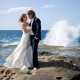 Copyright Tim Hensel photographer in Kent   bride and groom standing on rocks on beach with waves crashing in background amazing
