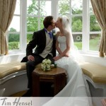 Tim Hensel photographer in Kent copyright couple sitting in bay window seat having a kiss just after ceremony aw