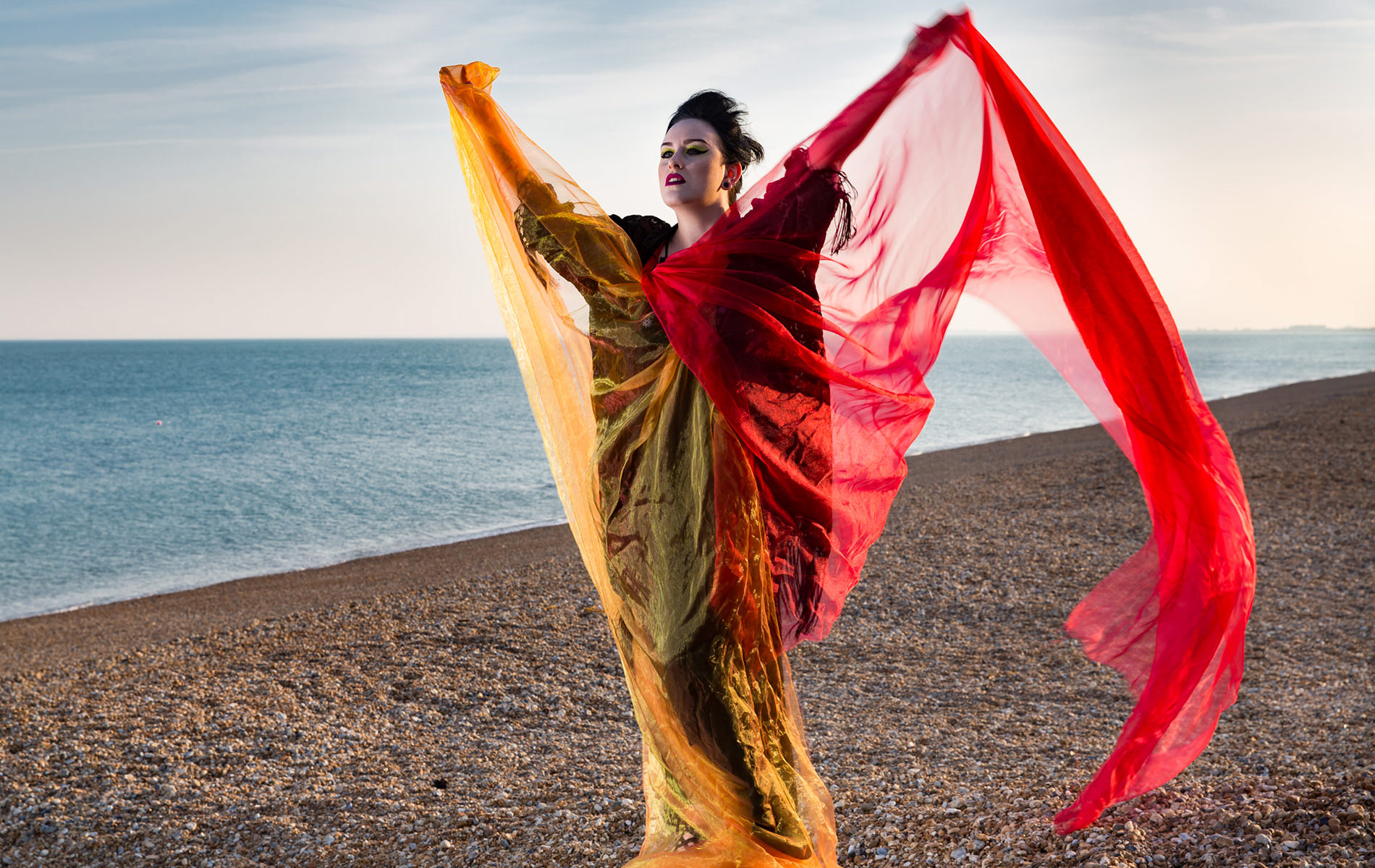 Portrait photographer Kent woman on beach with flowing vibrant gowns