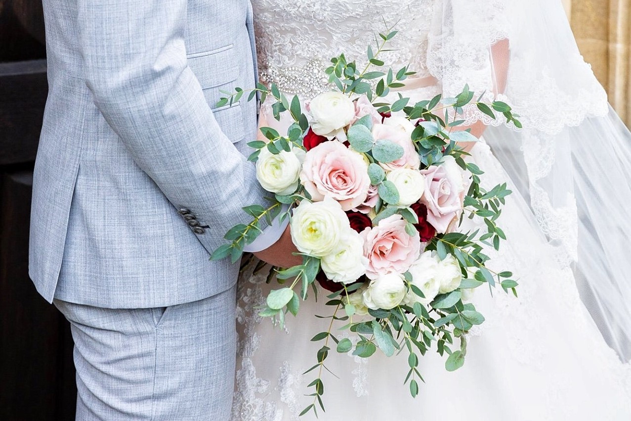 Picture of a bride and groom holdingroses property of Emily&Me florist Folkestone